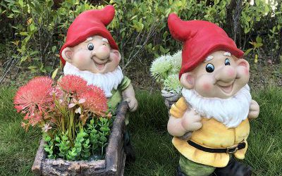 公園草坪上兩個(gè)玻璃鋼彩繪卡通背竹筐和推花盆小推車(chē)的小矮人雕塑