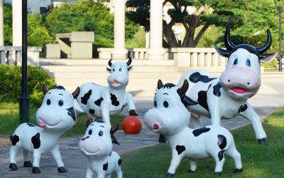 戶外小區一群玻璃鋼卡通奶牛雕塑