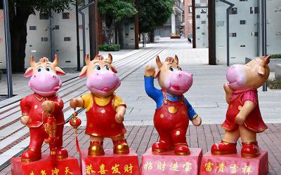 商場擺放四個喜慶招財的玻璃鋼卡通牛雕塑